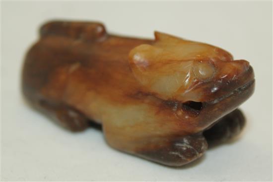 A Chinese celadon and brown jade figure of a recumbent lion-dog, Song dynasty or later, 5.7cm